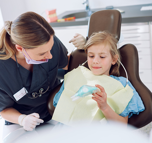 Mitarbeiterin mit Kind, das die Maske in der Hand hat