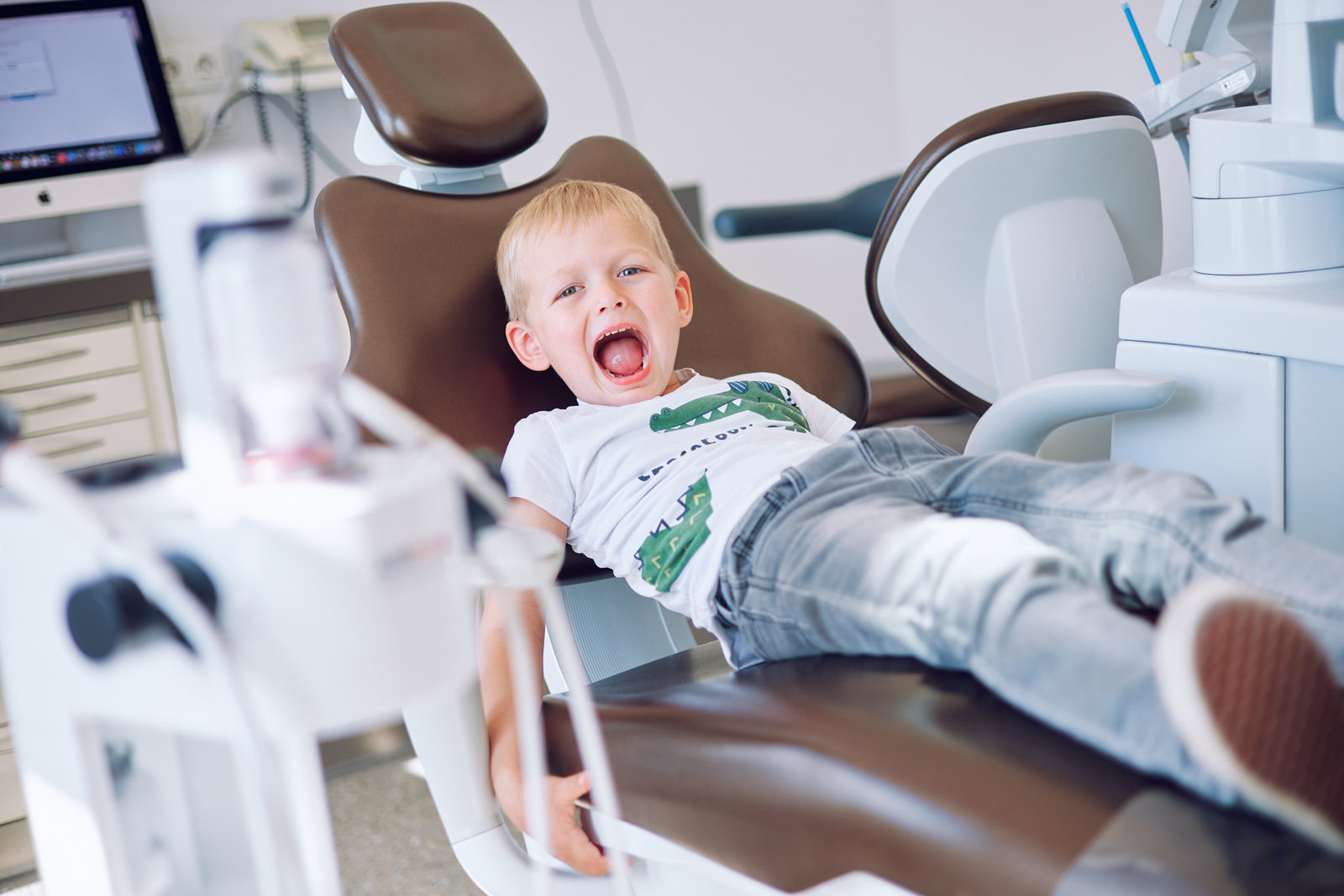 Kleinkind auf Praxisstuhl mit offenem Mund