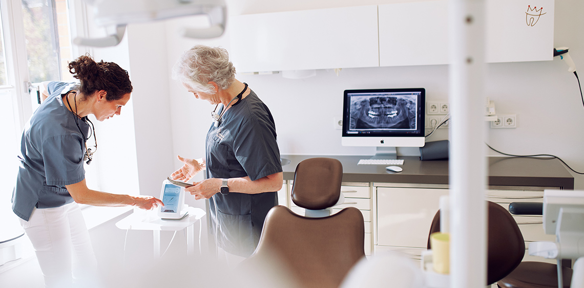 Sommer und Wacker besprechen etwas anhand einer kleinen Apparatur